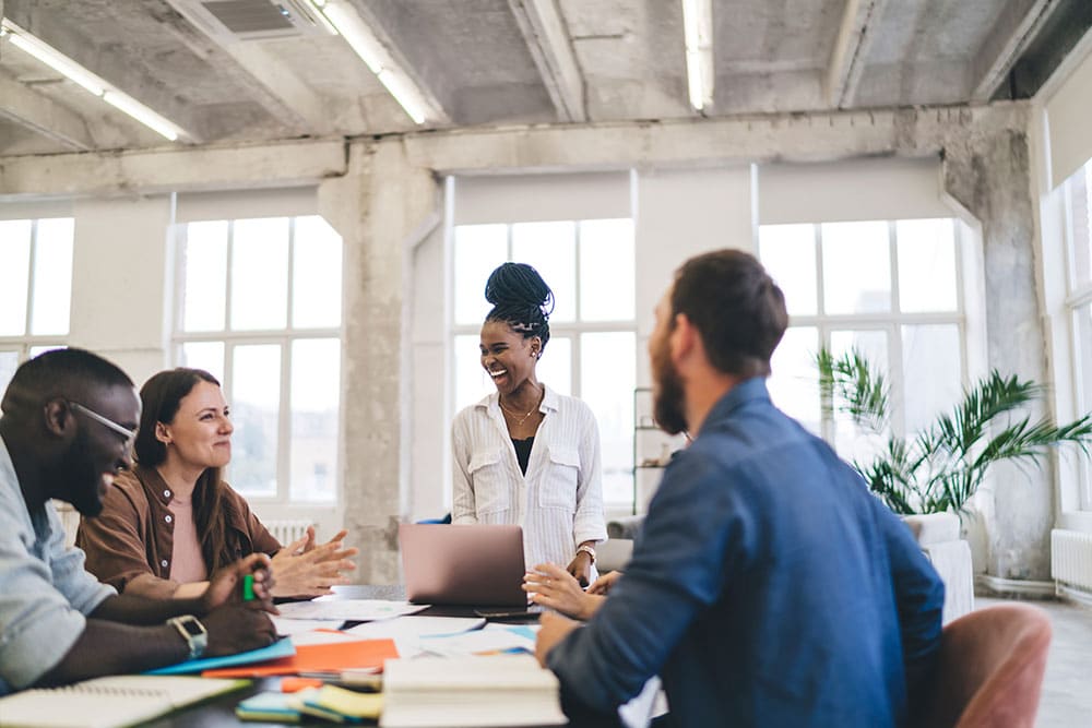 group of coworkers having meeting and laughing