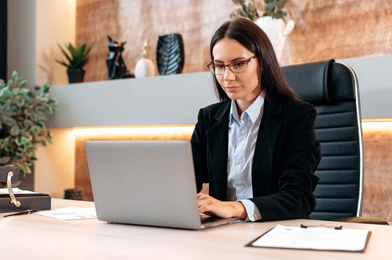 real estate agent with glasses on computer